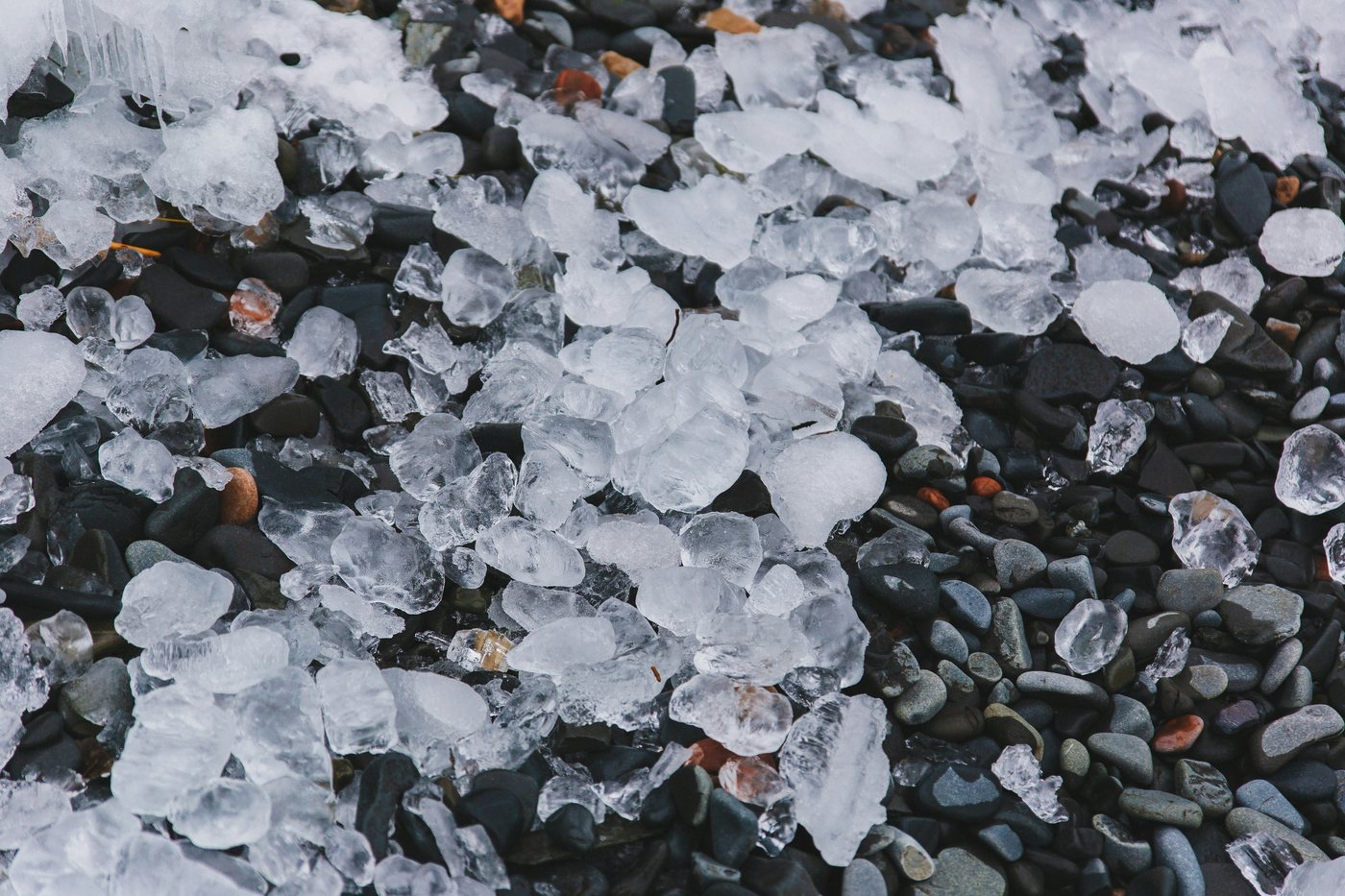 Hailstones on the ground next to a coin for scale